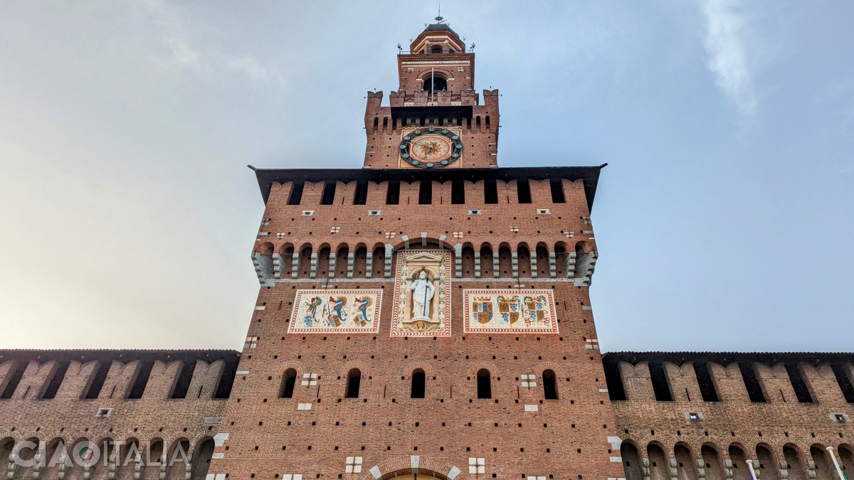 At the top of the tower, there is a clock and a statue of St. Ambrose, framed by the coats of arms of the rulers from the Sforza family.