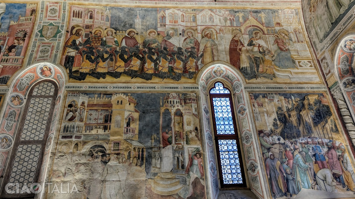 At the top of the fresco, members of the Lupi family are depicted, dressed in armor and accompanied by their patron saints, kneeling before the Virgin Mary.