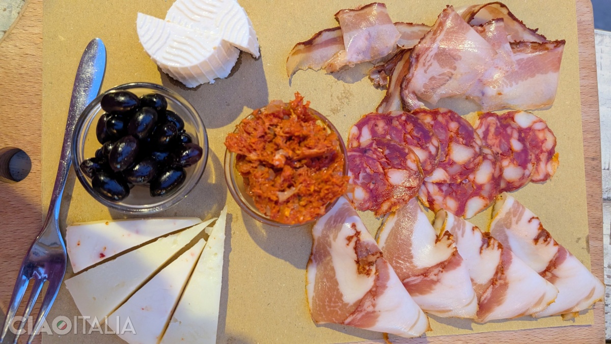 Cheeses are served alongside 'nduja and cured meats on a traditional Calabrian platter.