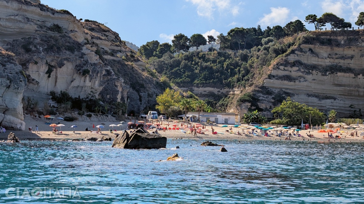 Riaci Beach is located in a bay protected by rocky cliffs.