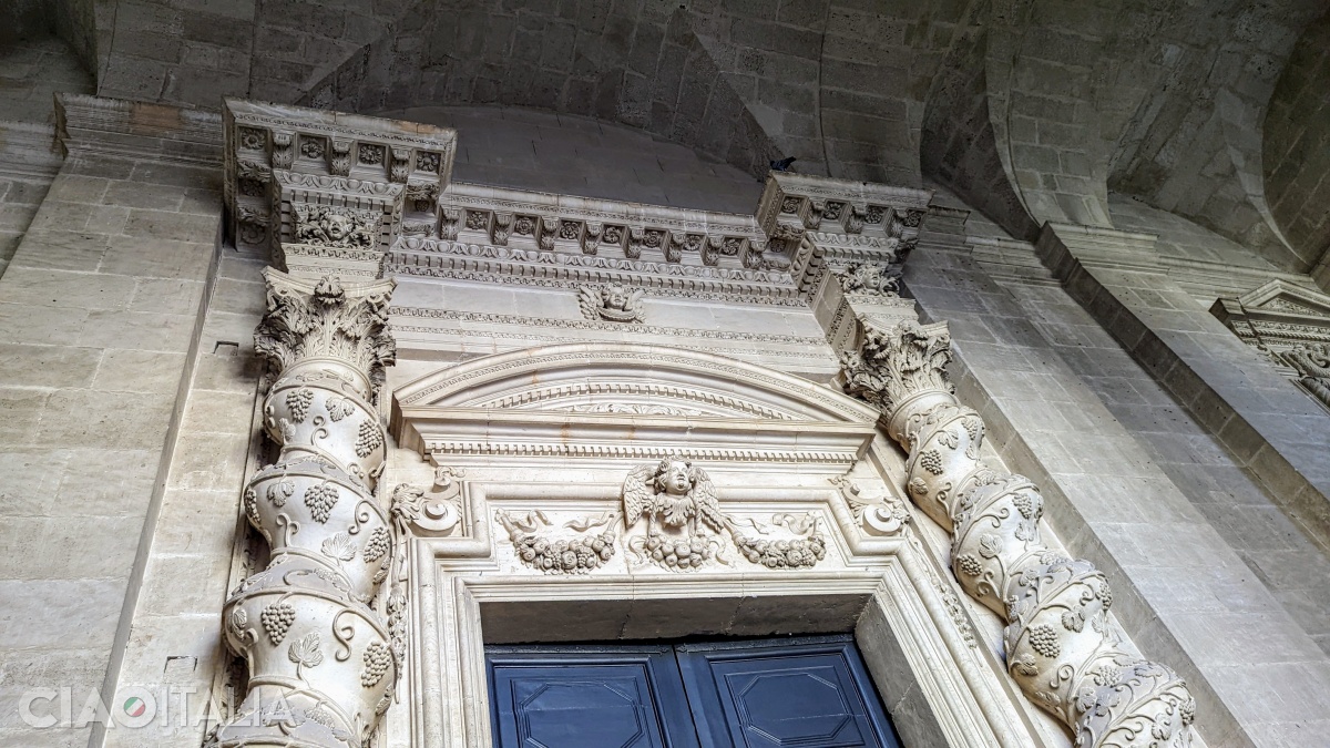 Two columns decorated with clusters of grapes frame the central portal of the cathedral.