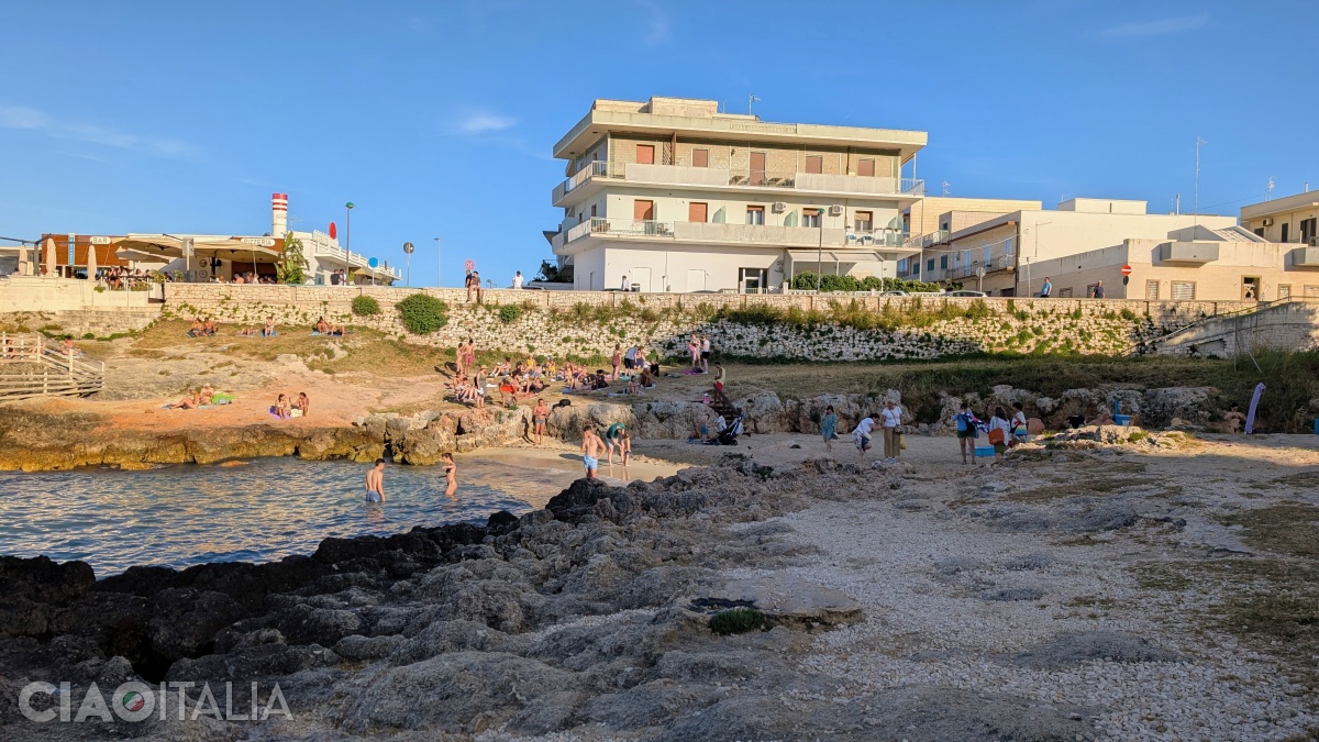 The beach is nestled in a sheltered cove between rocky cliffs.