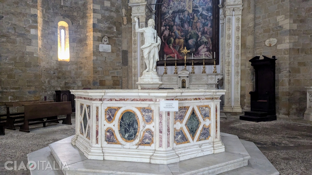 The marble baptismal font, with the statue of John the Baptist, dates from 1771. Behind it, you can see Pomarancio's 16th-century painting.