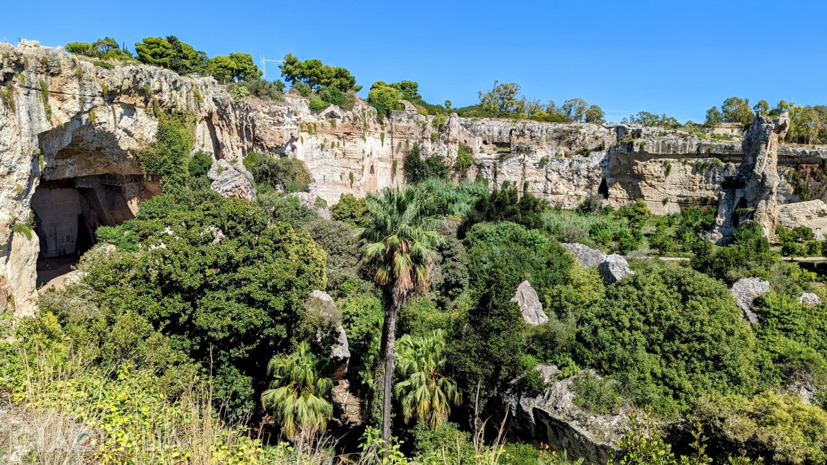 Latomia del Paradiso is a stone quarry surrounded by lush vegetation.