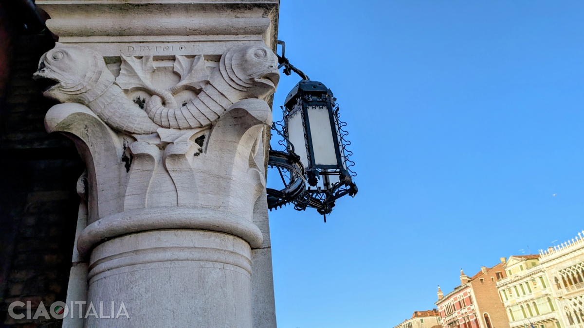 Capital on the side facing the Grand Canal, depicting two fish with intertwined tails, signed D. Rupolo, and a wrought-iron lamp made by Umberto Bellotto