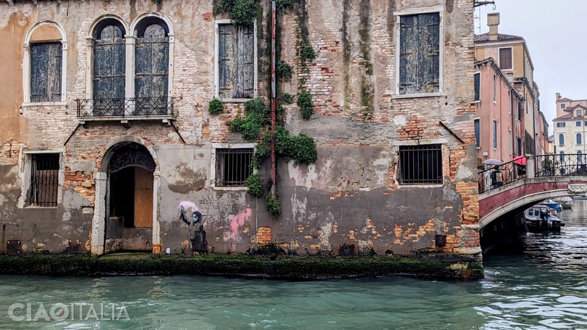 At the bottom of the building, to the right of the door, there is a mural by Banksy.