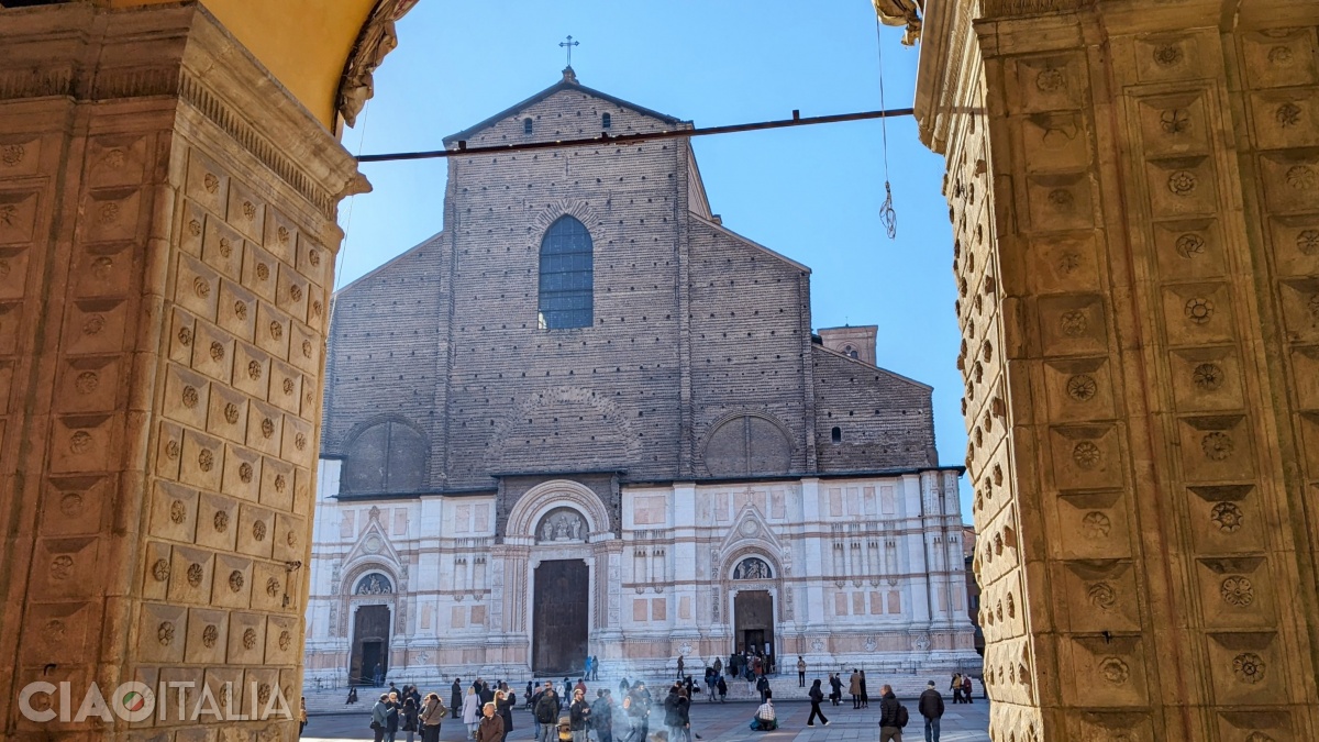 The Basilica of San Petronio seen from beneath the flower-decorated columns of the Palazzo del Podestà.