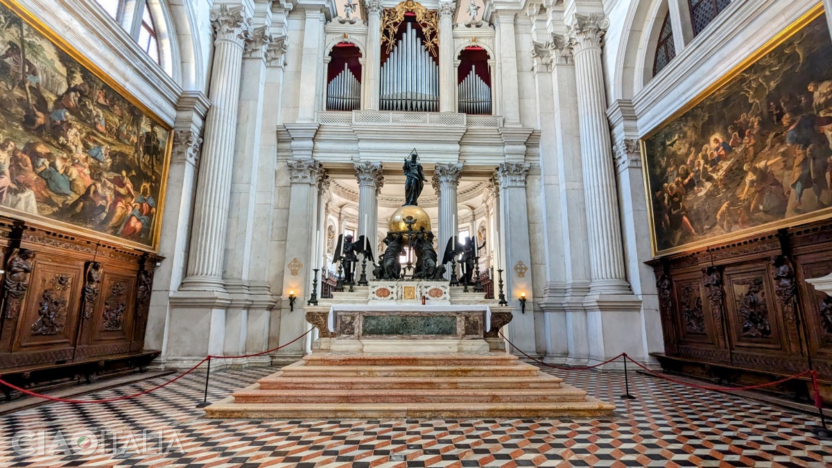 The main altar, framed by works by Tintoretto
