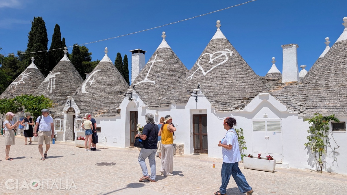 The conical roofs of the trulli bear various symbols.