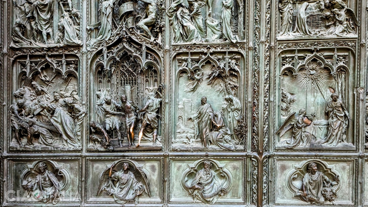 The bronze doors of the Milan Cathedral are carved with scenes from the life of Jesus and the Virgin Mary.