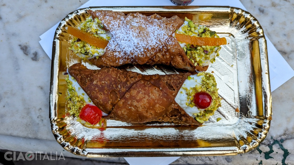 Pistachios and candied fruits are sprinkled over the "cannolo".