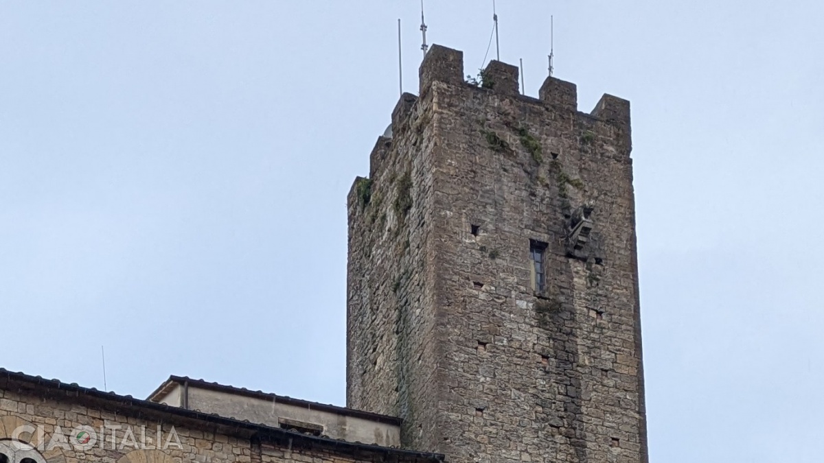 The mysterious figure stands in relief above the topmost window of the tower.