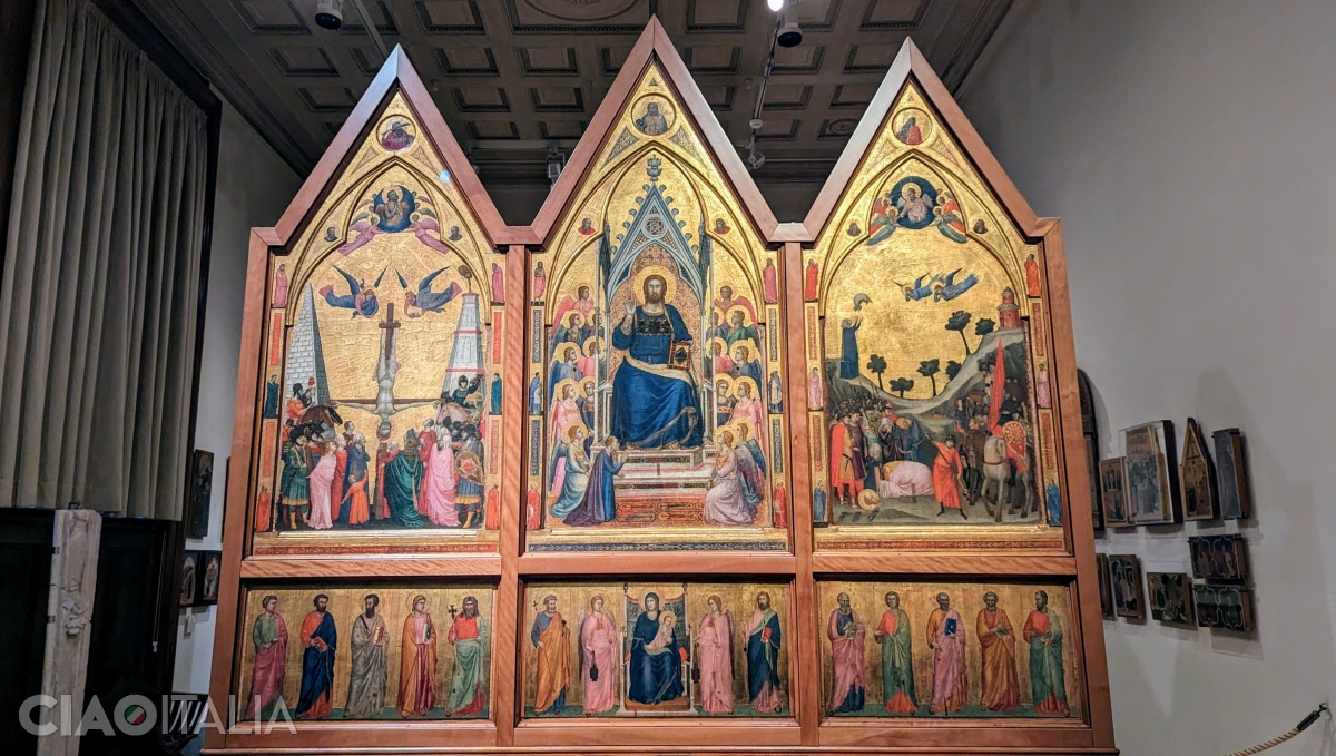 On the side facing the priest, Christ is depicted on the throne, with Cardinal Stefaneschi at his feet, to the left. On the side panels, the "Crucifixion of St. Peter" and the "Martyrdom of St. Paul" are painted. At the bottom is the "Virgin and Child, between two angels and the twelve apostles".