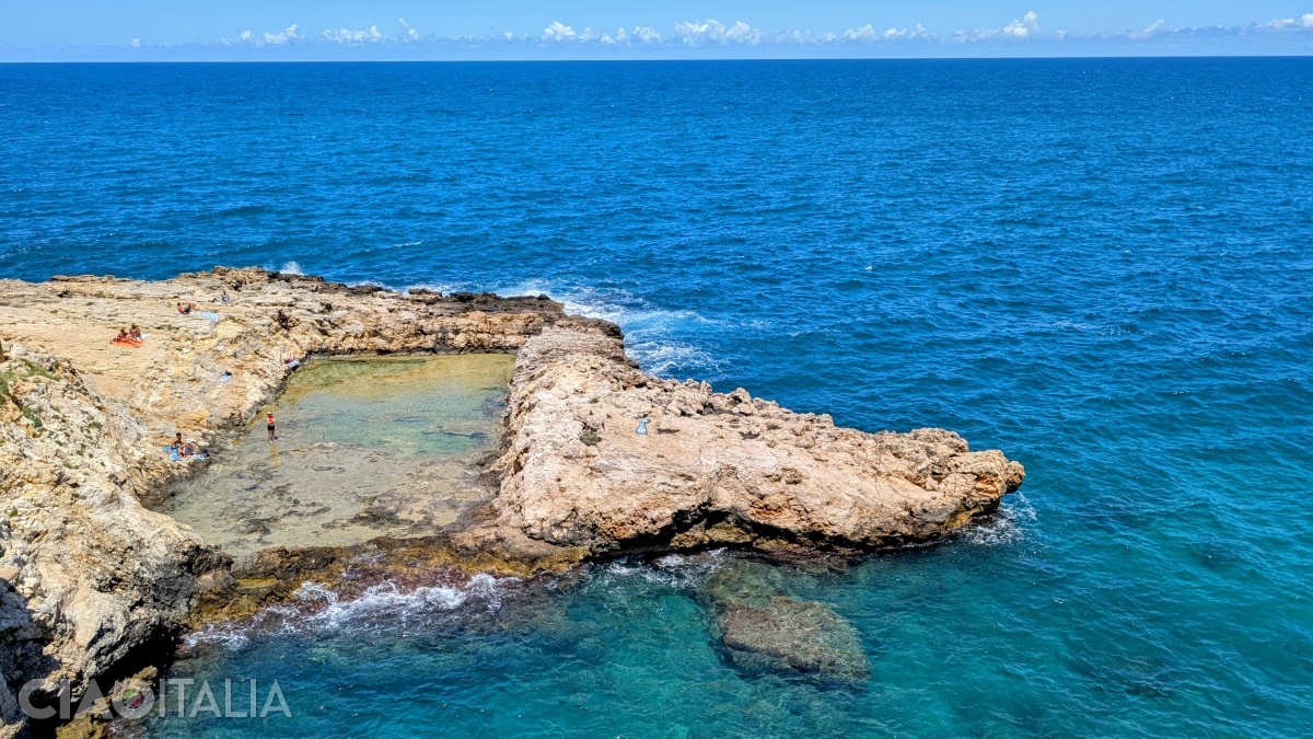 The natural pool is located on the rocky Grottone Beach.