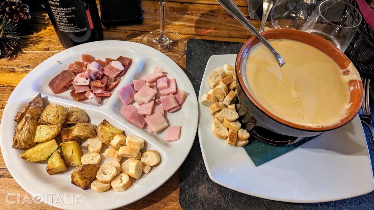 Fonduta is often accompanied by local cured meats and potatoes.